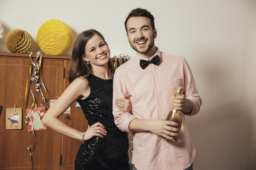 Couple holding bottle of Champagne on New Year's Eve