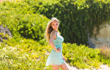 Fototapeta na wymiar portrait of blond woman in mint-colored dress outdoor