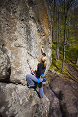 The girl climbs on the rock.