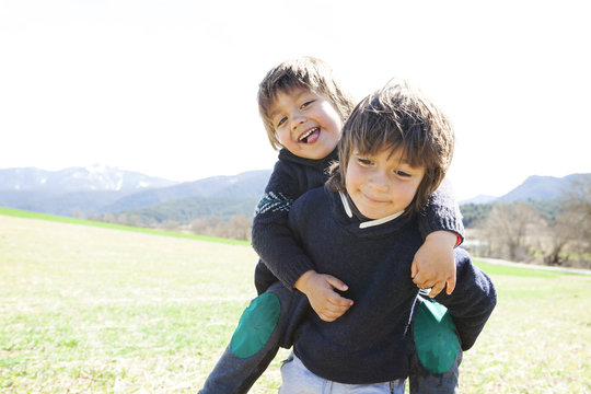 Portrait of little boy carrying his brother piggyback