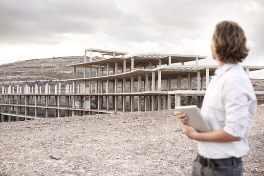 Spain, Fuerteventura, Jandia, architect looking at building shell