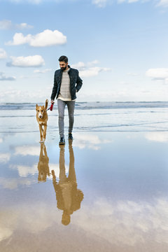 Man walking on the beach with his dog