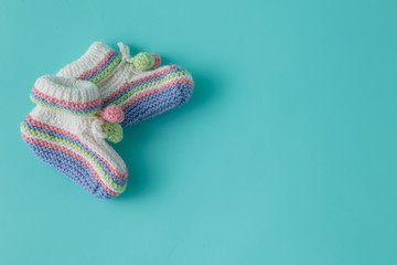 Newborn announcement template. Handmade knitted booties on plain