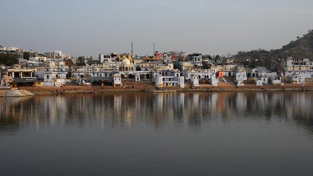 Panning shot of Pushkar city over holy Pushkar lake in Rajasthan, India.