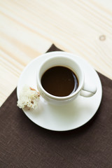 Cup of coffee on a brown tablecloth