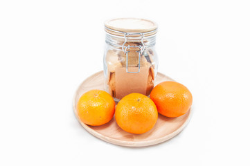 orange in a wood dish and cookie in jar.