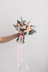 Beautiful wedding bouquet in hands of the bride. Peony rose, cotton, roses. Pink and Peach. Trendy and modern wedding flowers. Ideal photo for commercial. Space for your logo