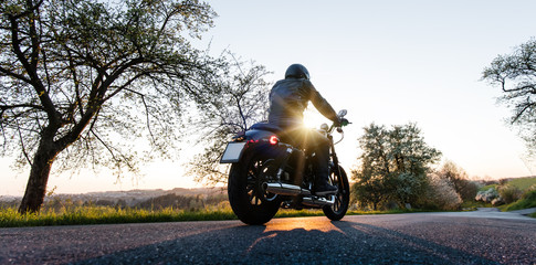Obraz premium Man seat on the motorcycle on the forest road.