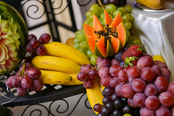 Grapes, bananas, avocados, strawberries placed on a table