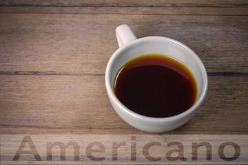 Hot coffee Americano in cup on wooden table.