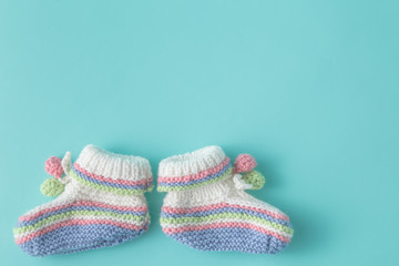 Newborn announcement template. Handmade knitted booties on plain