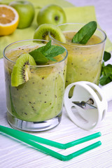 Green smoothie with mint and fruits on the wooden background