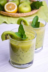 Green smoothie with mint and fruits on the wooden background