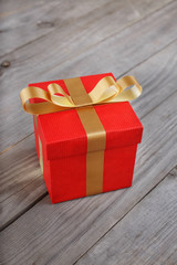 closed red gift box with gold ribbon