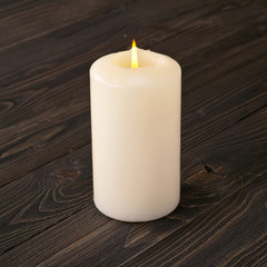burning candle on a dark wooden table