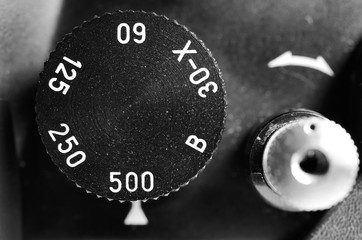 Fragment of old film camera. Top view dial of exposure and shutter button. Close up view. Macro. Selective focu. sVintage photo. Toning.