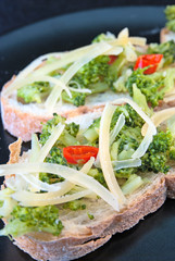 Toasts with broccoli, chili pepper and cheese flakes