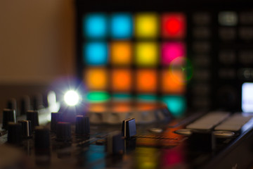 DJ console cd mp4 deejay mixing desk Ibiza house music party in nightclub with colored disco lights.