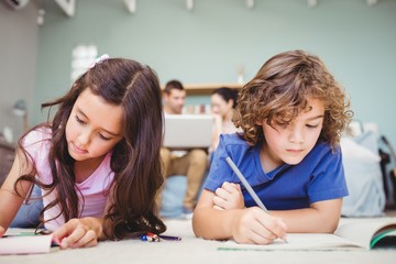 Close-up of children studying while parents in background at home