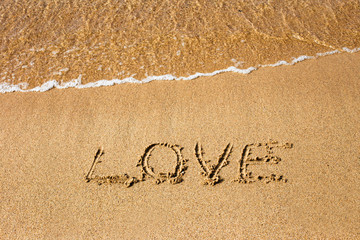 Inscription Love at the sand on the summer beach