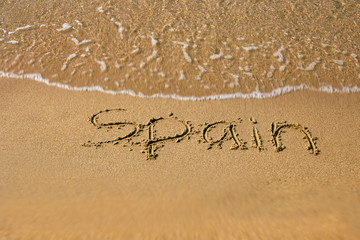 Inscription Spain at the sand on the summer beach