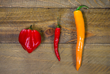 Colored chili peppers on wooden table