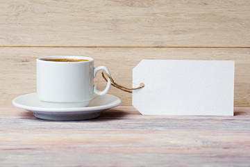 Coffee cup with empty label over old wooden background