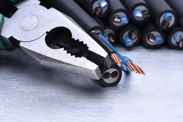 Electrician tool pliers and cables closeup