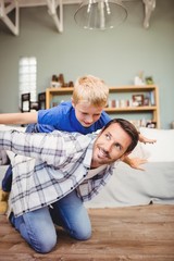 Fototapeta premium Happy father playing with son on hardwood floor