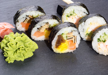 Fresh sushi rolls on dark gray slate background