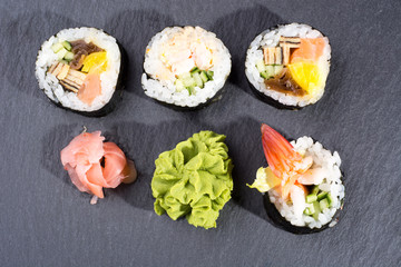 Obraz na płótnie Canvas Sushi on dark slate board with ginger and wasabi