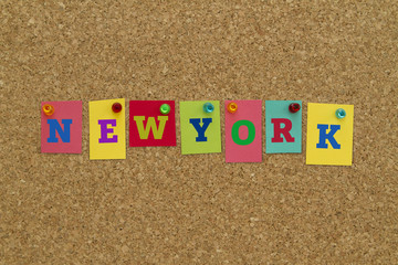 New York written on colorful notes pinned on cork board. 