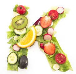 Letter K made of salad and fruits