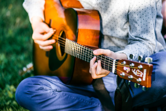 Man playing acoustic guitar close up outdoors