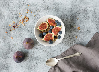 Healthy breakfast. Bowl of oat granola with yogurt, fresh blueberries and figs
