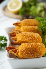 Fried crab claws with cucumber, lemon, lettuce and parsley