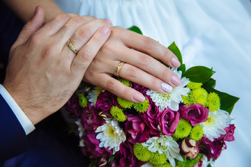 Obraz na płótnie Canvas marriage hands with rings. on the wedding bouquet background
