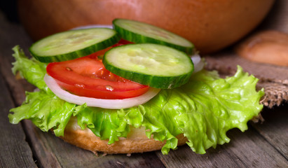 Sandwich with salad and other vegetables on old gray boards