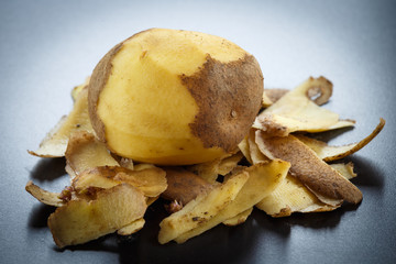 Raw peeled potatoes and potato peelings
