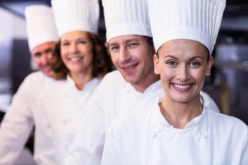 Happy chefs team standing together in commercial kitchen