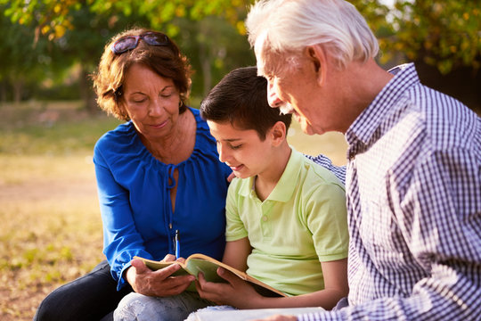 Grandparents Helping Child Doing School Homework