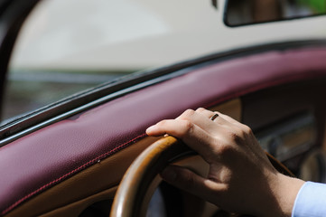 Hand on steering wheel of retro car