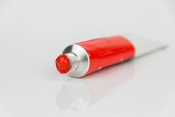 red color paint tube on white background