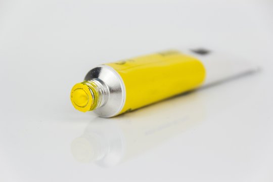 yellow paint tube closeup on white