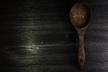 Wood spoon on black wood texture background