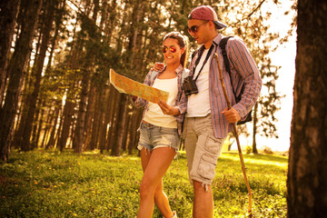 Couple hiking. Using map to get good direction.Sunset.