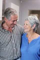 Happy elderly man and woman standing in kitchen