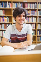 Portrait of happy young student using his laptop