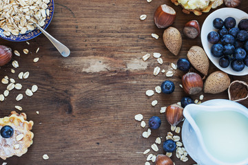 Breakfast with almond, hazelnuts and oatmeal on dark wooden table. Rustic style.Top view. selective focus.