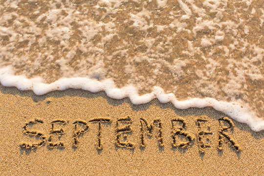September - word drawn on the sand beach with the soft wave. Months series of 12 pictures.